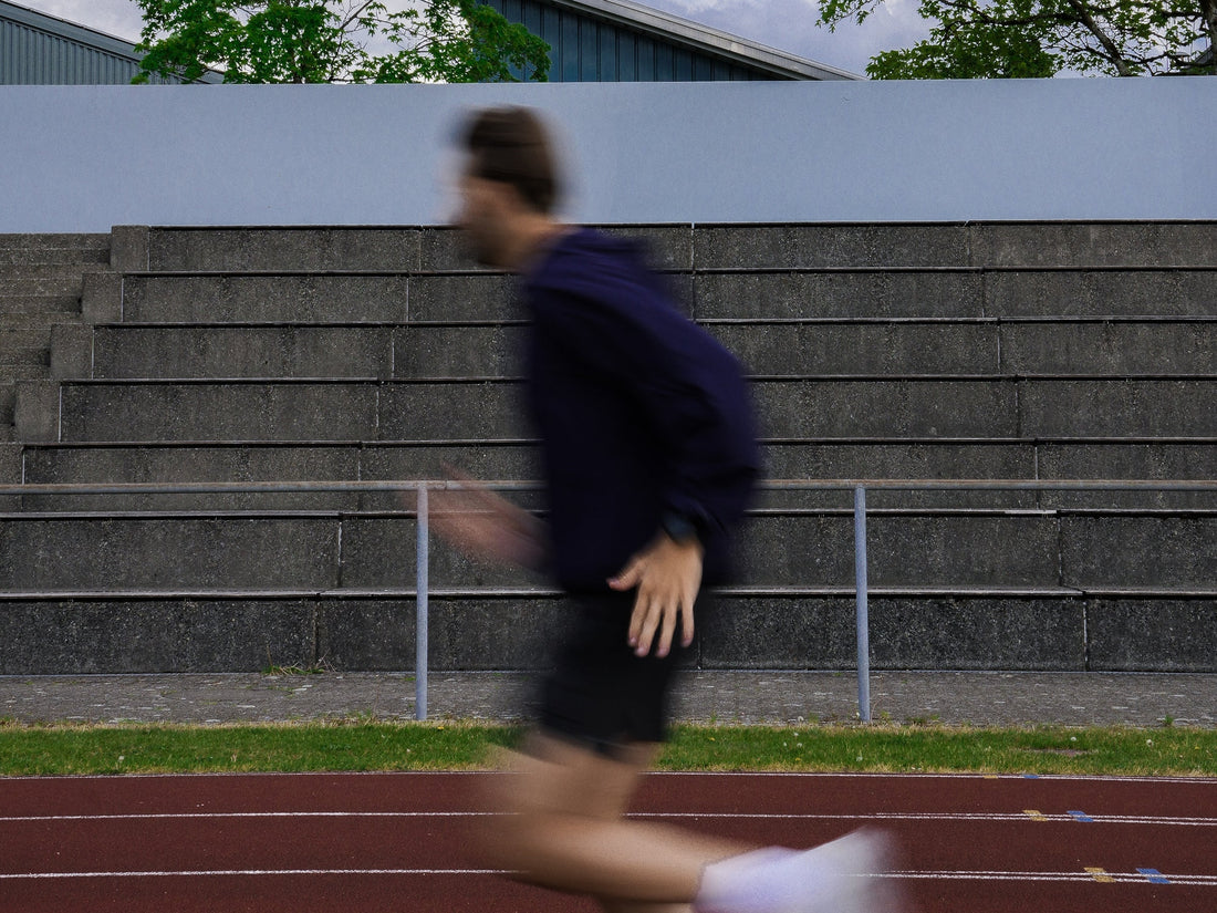 Läufer im Athlix Windbreaker sprintet an der Tribüne vorbei – mentale Stärke in harten Sessions