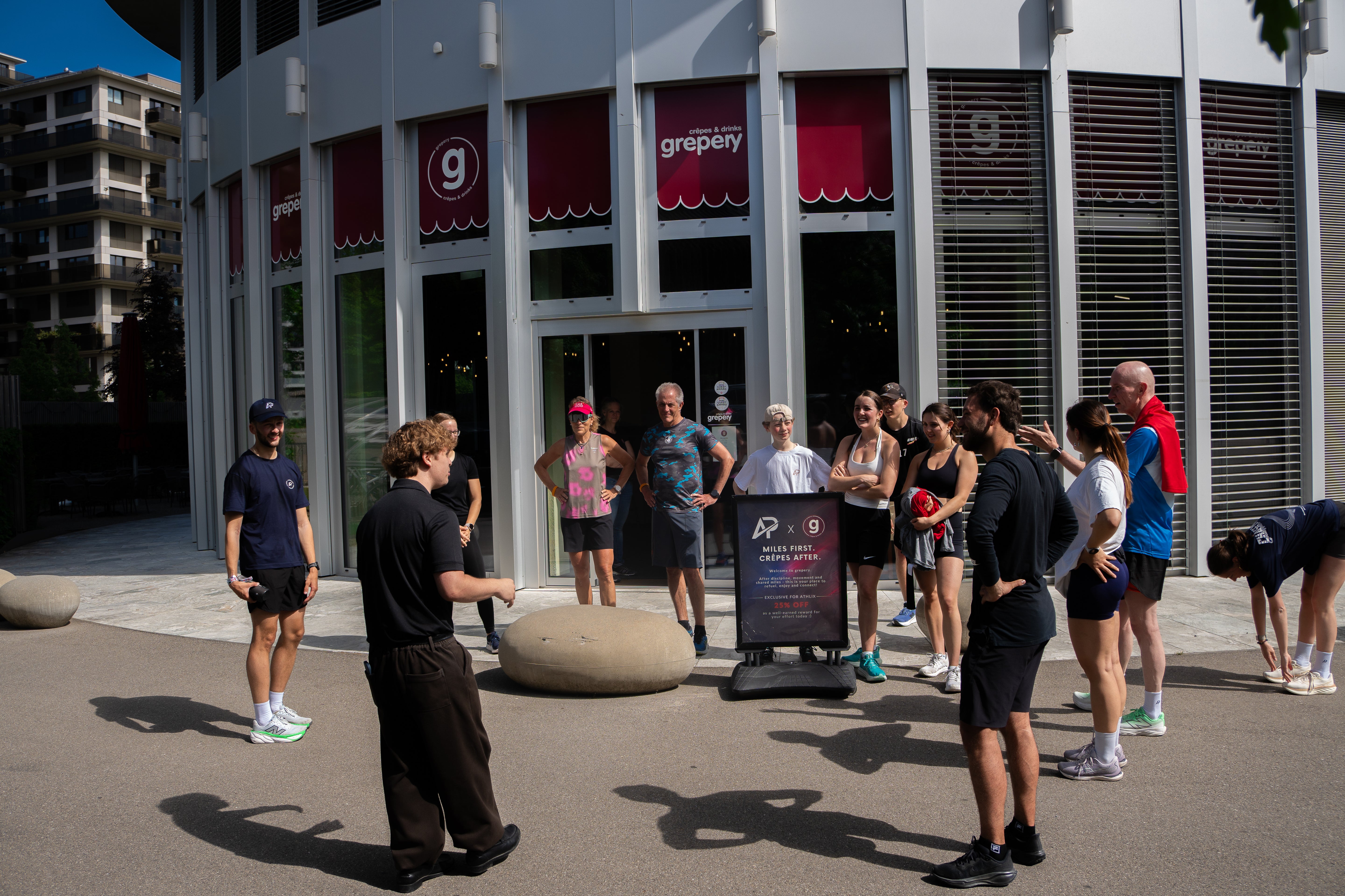 Athlix Community versammelt sich vor dem Café Grepery zum gemeinsamen Run und Coffee-After-Event an einem sonnigen Morgen.