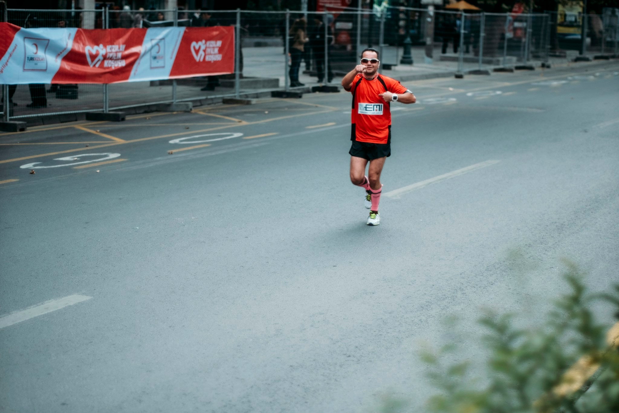 Läufer im roten Trikot läuft dynamisch auf der Strasse – Renntempo und Pacing im Ausdauersport