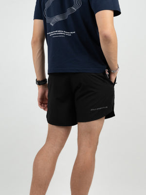 Mann von hinten in schwarzen Laufshorts und dunkelblauem T-Shirt, Sportuhr am Handgelenk