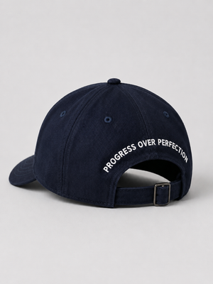 Dunkelblaue Cap von hinten mit Schriftzug Progress over Perfection und verstellbarem Riemen