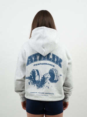 Frau von hinten im hellgrauen Hoodie mit blauem Athlix-Performance-Print und Hantel-Grafik